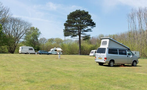 Naturist campsite at Brocken Hurst, home of the naturist foundation featuring tents and caravans surrounded by woodlands
